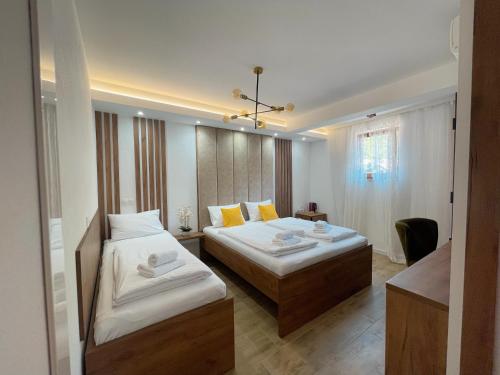 Habitación de hotel con 2 camas y ventana en Apartments and rooms SMILE, en Mostar