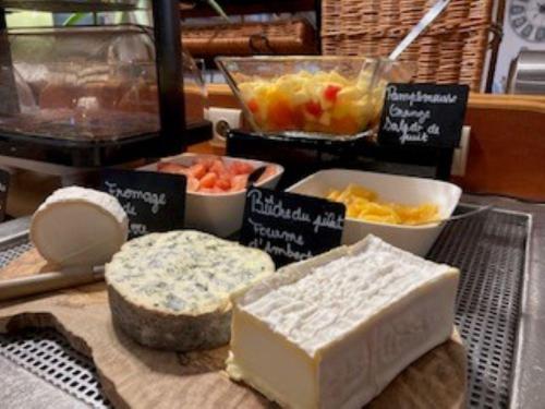 a bunch of different types of cheese and bowls of fruit at Kyriad Hotel Montpellier Centre Antigone in Montpellier