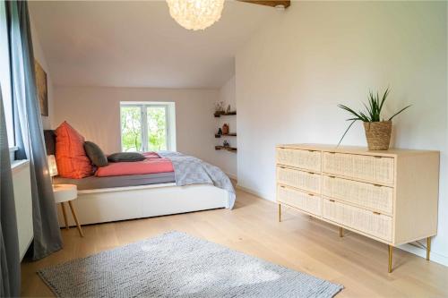 a bedroom with a bed and a dresser and a window at Studio EINS in Oersberg