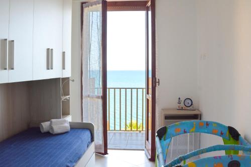 una camera con letto e porta di accesso a un balcone di Casa Stella Marina a Pozzallo