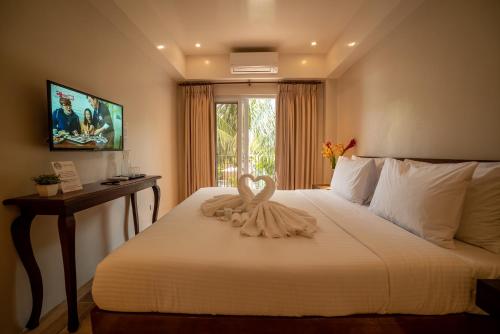 a bedroom with a white bed with a swan on it at Bernardo's Lantia Hotel in Basco