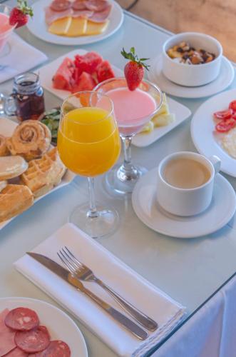 a table with plates of food and glasses of juice at Hotel de Sal Luna Salada in Colchani