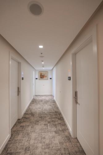 an empty hallway with white walls and doors at Republika Hotel in Sarandë