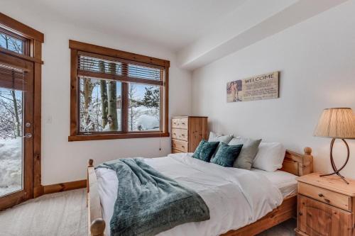 1 dormitorio con cama y ventana en 1061- Spacious Mountain Townhouse with Garage Shared Hot Tub and Pool en Steamboat Springs