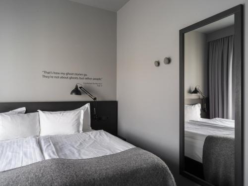 a bedroom with a large mirror and a bed at Skuggi Hotel by Keahotels in Reykjavík