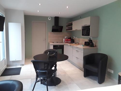 une cuisine avec une table et des chaises dans une pièce dans l'établissement Studio des Prés, à Fougères