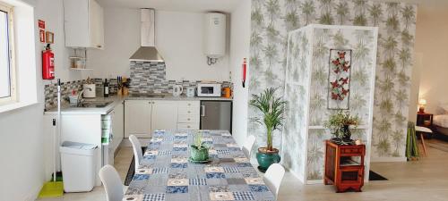 a kitchen with a table and chairs and a kitchen with white cabinets at Quinta De Oliveiras in Beco