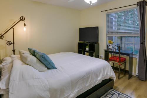 a bedroom with a bed and a tv and a window at Tallahassee Townhome with Patio Near FSU Campus! in Tallahassee