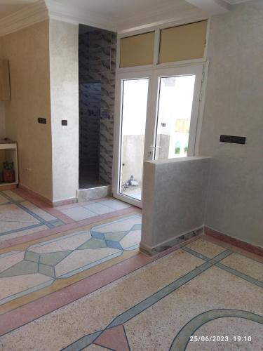 Habitación con ventana grande y suelo de baldosas coloridas. en Villa Agadir Maroc, en Agadir