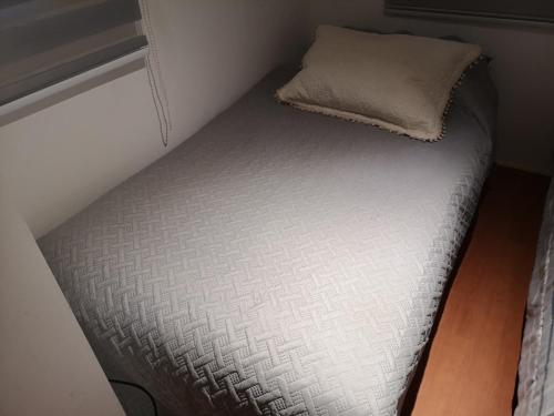 a small bed with a pillow on top of it at CABAÑA LIRCAY - 2 habitaciones 48M2 para 4 personas in San Clemente