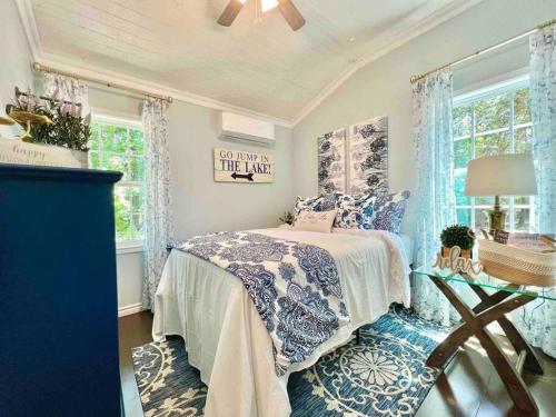 a bedroom with a bed and a table and windows at SLEEPS SIX - Rent Entire WATERFRONT Cabin #2 in Etoile