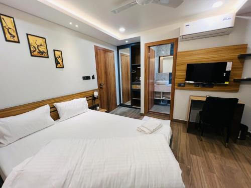 een slaapkamer met een groot bed en een televisie bij HOTEL ROYAL VANILLA in Siliguri