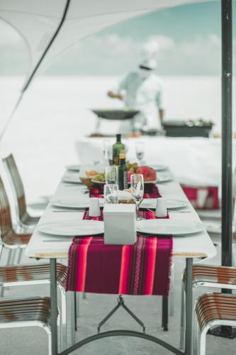 a long table with white plates and wine glasses at Hotel de Sal Luna Salada in Colchani