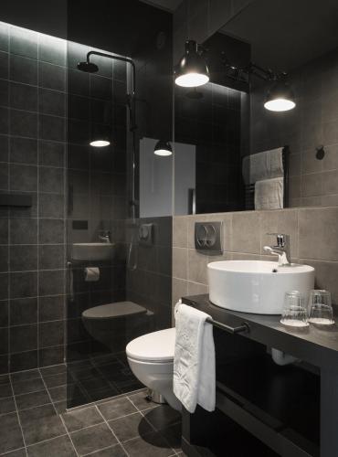 a bathroom with a sink and a toilet and a mirror at Skuggi Hotel by Keahotels in Reykjavík