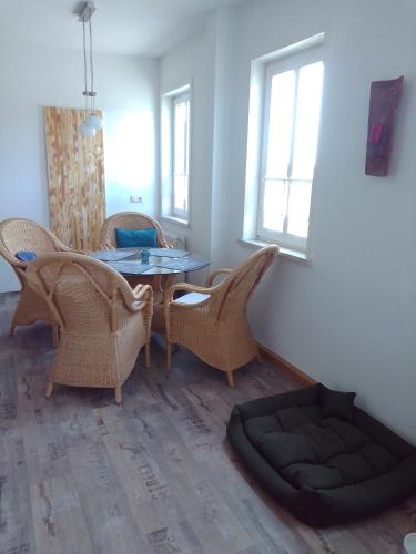 a dining room with a table and chairs and a dog bed at Ferienwohnung Zuschke in Klipphausen