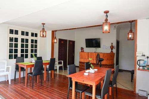 a dining room with wooden tables and chairs at Thulusdhoo Inn in Thulusdhoo