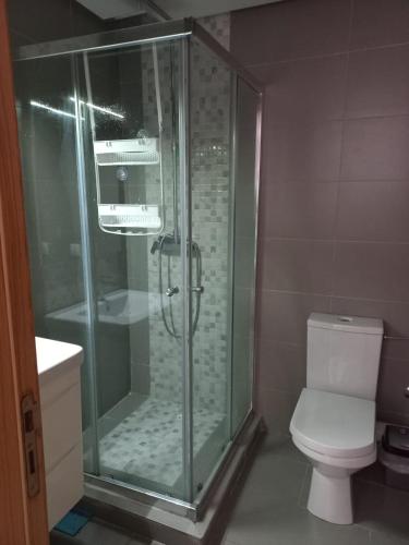 uma casa de banho com uma cabina de duche em vidro e um WC. em appartement luxe em Mohammedia