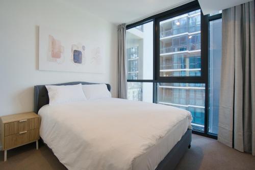 a bedroom with a large bed and a large window at Contemporary 3BR Paradise on Franklin Street in Adelaide