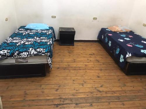 2 camas en una habitación con suelo de madera en Safary Hotel en El Cairo