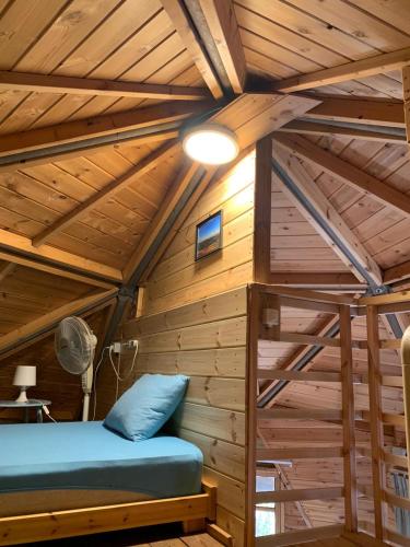 a room with a bed in a wooden cabin at בקתת עץ בחורש במנות - דום גיאודזי - Wooden cabin in Manot in Manot