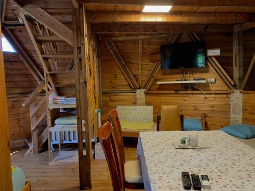 a dining room with a table and a television in a cabin at בקתת עץ בחורש במנות - דום גיאודזי - Wooden cabin in Manot in Manot