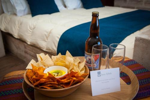 a table with a bowl of chips and a bottle of beer at Hotel de Sal Luna Salada in Colchani