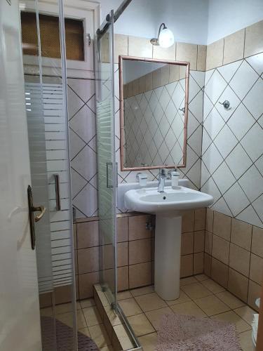 a bathroom with a sink and a mirror and a shower at Semeli Guesthouse in Karpenision