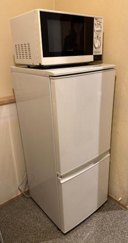 a microwave sitting on top of a refrigerator at Hananosato Hotel 池袋本店 in Tokyo