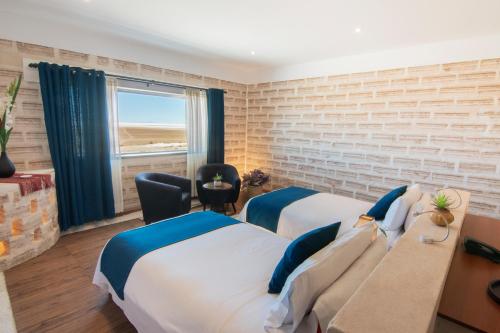 a hotel room with two beds and a window at Hotel de Sal Luna Salada in Colchani
