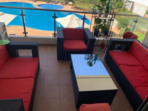 a patio with couches and a table and a pool at Bahia Golf Beach, Bouznika in Bouznika