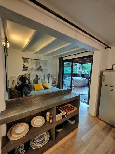 a living room with a bed and a refrigerator at OHANA Jungle Lodges in Les Avirons