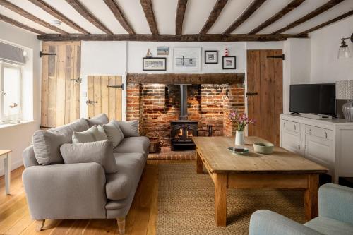 a living room with a couch and a fireplace at 7 Church Street, Southwold in Southwold