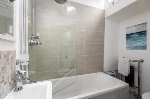 a bathroom with a tub and a sink at 7 Church Street, Southwold in Southwold