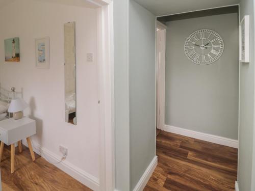 a hallway with a clock on the wall at South Cottage Howick in Craster