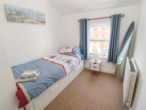 ein kleines Schlafzimmer mit einem Bett und einem Fenster in der Unterkunft 22 St Marys Walk in Scarborough