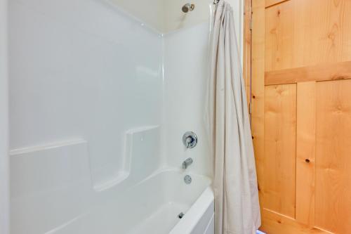 a bathroom with a tub and a shower curtain at Cozy Lake Wissota Escape with Community Dock! in Chippewa Falls
