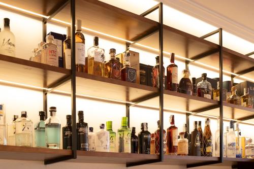 a shelf filled with lots of bottles of alcohol at Albariza Hotel Boutique in Sanlúcar de Barrameda