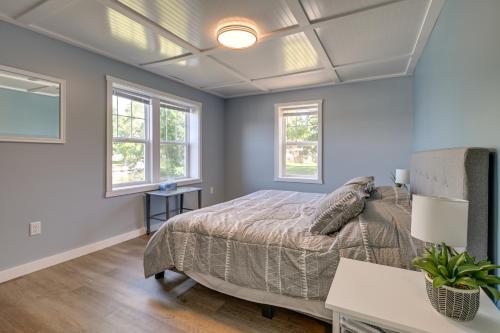 a bedroom with a bed and two windows at Chippewa Falls Getaway with Community Lake Access! in Chippewa Falls