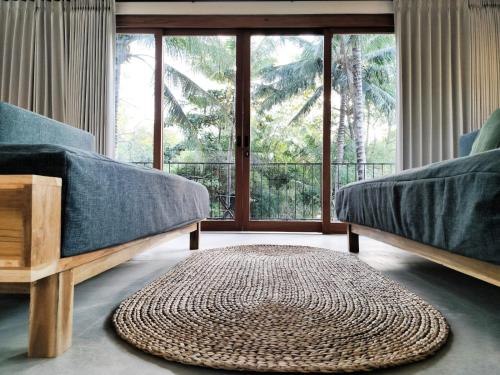 a living room with two beds and a rug at Villa Luna - Gili Air in Gili Air
