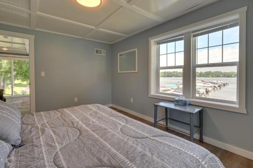 a bedroom with a bed and a view of the water at Chippewa Falls Getaway with Community Lake Access! in Chippewa Falls