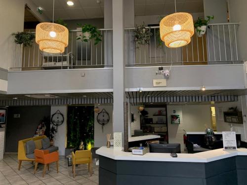 un hall d'un magasin avec des chaises et des lumières dans l'établissement Kyriad Hotel Montpellier Centre Antigone, à Montpellier