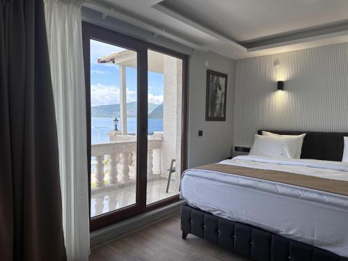 White Life Hotel & Cafe في Bitlis: غرفة نوم بسرير ونافذة كبيرة