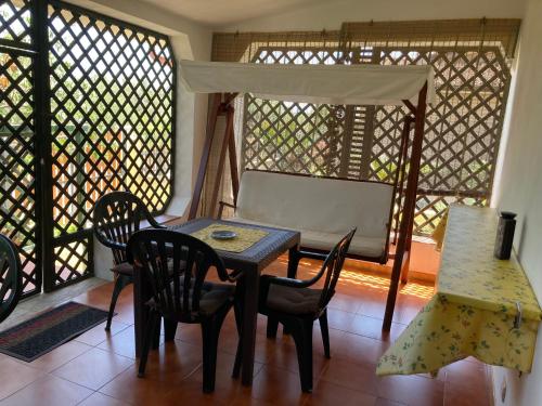 a dining room with a table and chairs and a window at Araxi in Villa San Pietro