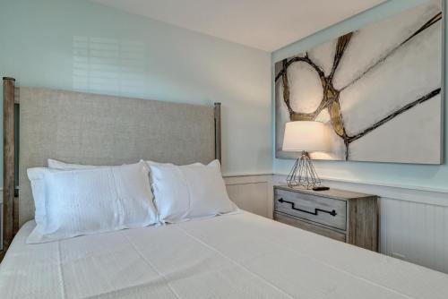 a bedroom with a bed and a lamp on a table at Loggerhead Inn and Suites in Surf City