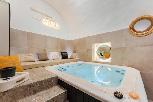 a large bath tub in a room with a couch at Anima Suite - Sauna - Jacuzzi e Cucina in Procida