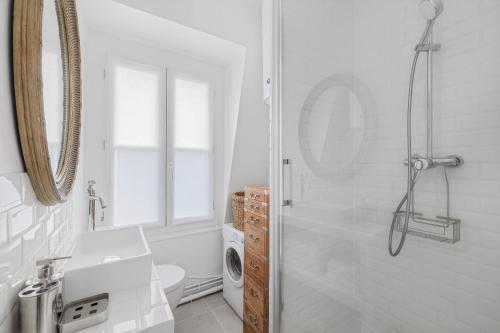 baño blanco con ducha y lavamanos en Benjamine en París