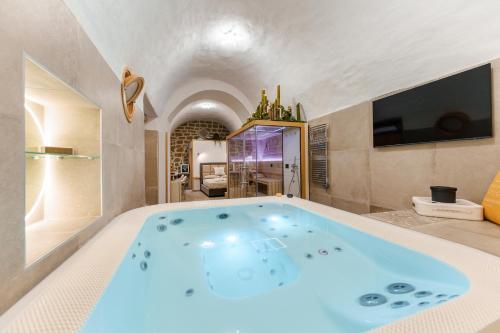 a large bath tub in a room with a tv at Anima Suite - Sauna - Jacuzzi e Cucina in Procida