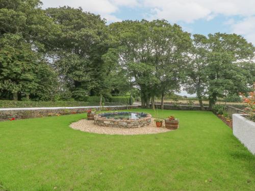 a backyard with a fire pit in the grass at Bryn Tirion in Holyhead