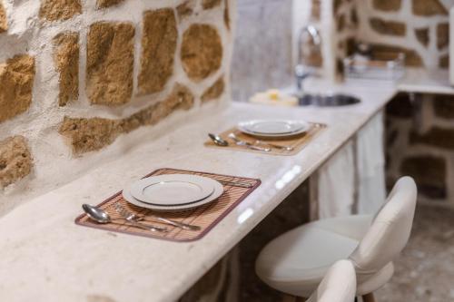 a kitchen counter with plates and utensils on it at Anima Suite - Sauna - Jacuzzi e Cucina in Procida