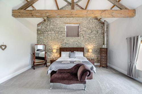 a bedroom with a large bed and a stone wall at Stubbs Grange Barn in Fenwick
